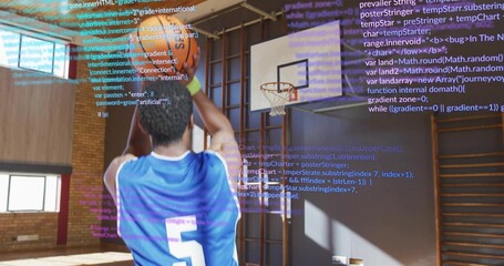 Taking jump shot in blue 5 jersey at school gym, with basketball and programming code overlay