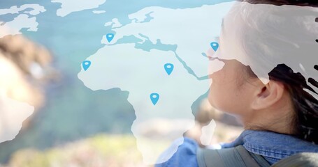 Obraz premium Gazing traveler carrying backpack at hilltop, with map overlay and blue location pins, copy space