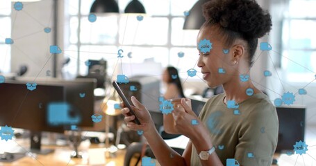 African American woman in blouse holding phone and mug in office, with floating icons, copy space