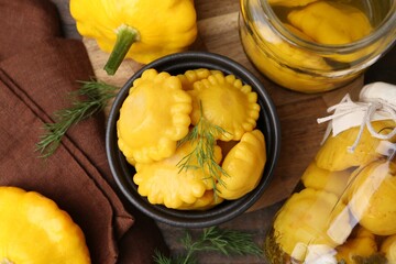 Fresh and pickled pattypan squashes on wooden table, flat lay
