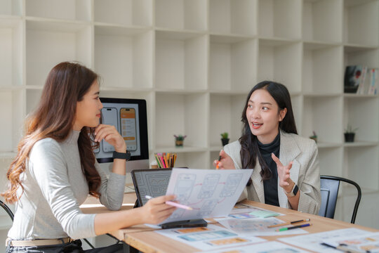 Asian women designers collaborating on user interface development
