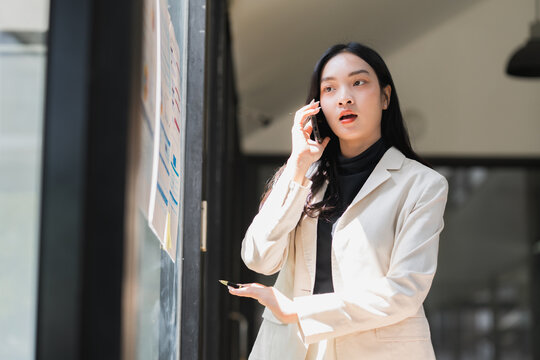 Businesswoman talking on phone discussing business in office - Powered by Adobe