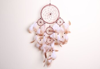 Beautiful dream catcher hanging against light grey background