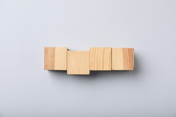 Wooden cubes on light background, top view