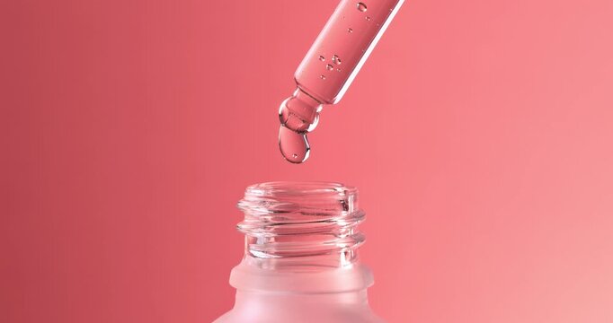 Close-up of a cosmetic gel serum with bubbles dripping from a dropper into a bottle.