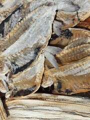 Dried fish fillets and tails laying on market stall