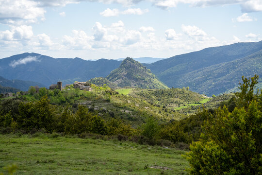 a small village nestled at the foot of a hill in Pyrenees mountains