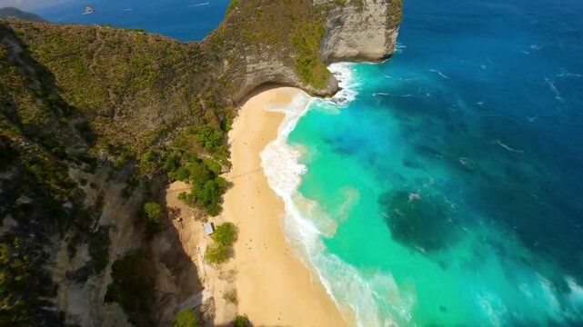 FPV drone diving down a clff to reveal Kelingking Bech, Bali.