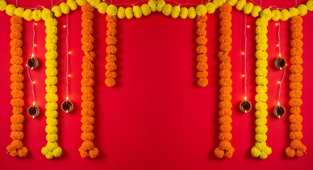 Festive Marigold Garland and Oil Lamps Decoration on Vibrant Red Background