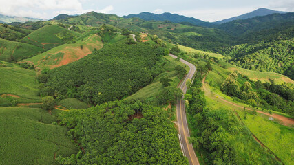 Aerial view of the greenery hills and mountain road by drone