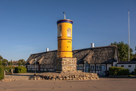 Historic yellow bell tower and thatched roof building in Nordby, Sams�