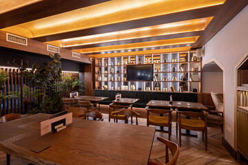Stylish modern coffee shop with wood walls, warm lights, and green seating