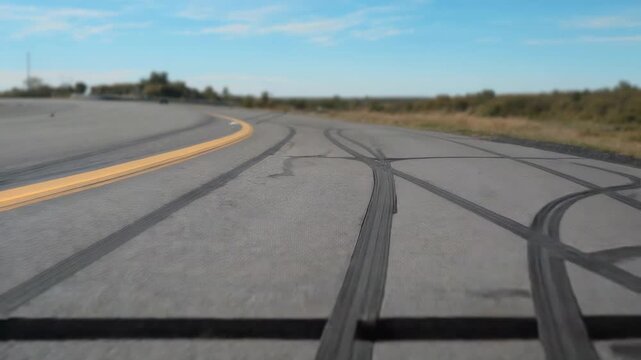 Entering left edge white RC car performing drifts on runway, carving skid patterns, copy space - Powered by Adobe