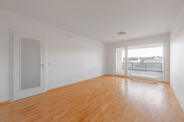 Bright and spacious living room with large windows and wooden floor in modern apartment