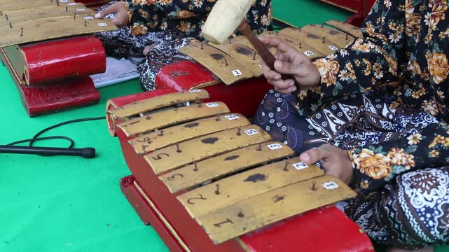Indonesians are playing one of the traditional instruments from Java. Gamelan Musician Plays, Traditional Instruments. 
