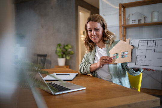 Female architect collaborating on house plan through video call