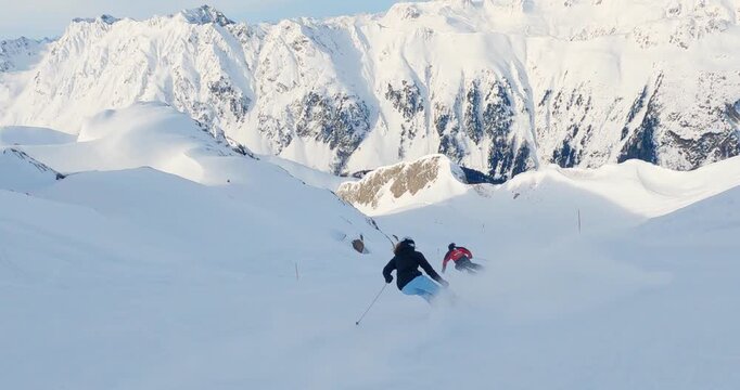 Sporty skiing with great ski technique professional ski couple long turns skiing with a great winter view. Blue sky white fresh powder snow long hair and modern ski equipment 4k follw camera