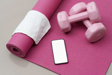Wellness. Fitness essentials including a yoga mat, dumbbells, and smartphone for an active lifestyle.