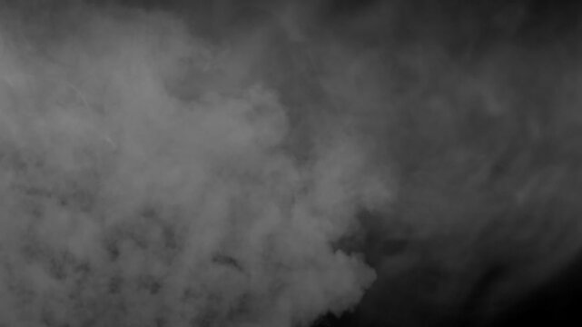 Realistic white smoke or fog slowly billows from bottom of frame on black background. Use as overlay for atmospheric, moody, or mysterious scenes