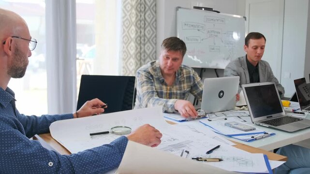 business meeting underway, executives analyze budgets and future predictions in professional setting, three team members collaboratively review company budgets and discuss forecasts in calm
