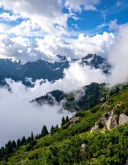 High-altitude scene of cloud-covered mountains and lush green slopes
