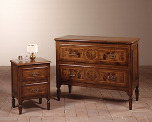 Still life of a classic-style wooden chest of drawers and bedside table
