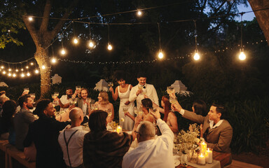 Nighttime garden wedding reception celebration with friends and family under string lights