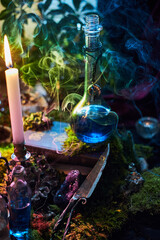 glass bottle filled with a vibrant blue potion sits on a wooden surface surrounded by moss, candles, and swirls of colorful smoke. atmosphere feels magical and enchanting