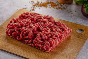 Raw minced beef meat over board