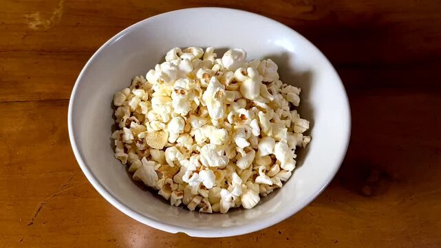 Popcorn (popped corn, popcorns or pop-corn) is a variety of corn kernel which expands and puffs up when heated. Popcorn served in white bowl