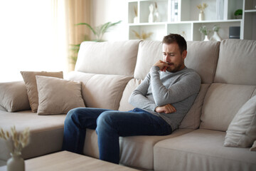 Obraz premium Sad man complaining alone on a sofa at home