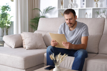 Serious man reading paper document at home