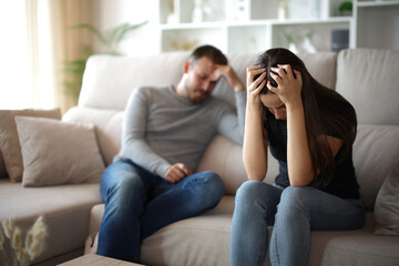 Desperate wife complaining beside her sad husband