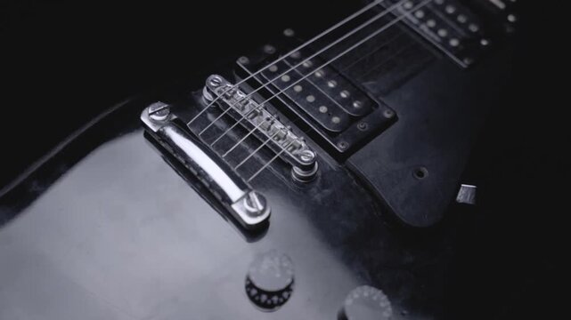 Cinematic details of electric guitar close-up in dark studio lighting