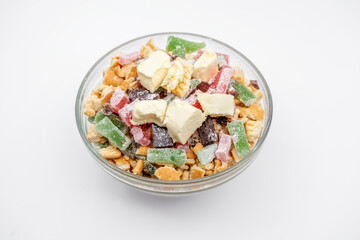 a clear glass bowl filled with ingredients for a cake, Broken biscuits, chopped Turkish delight and pieces of butter on top