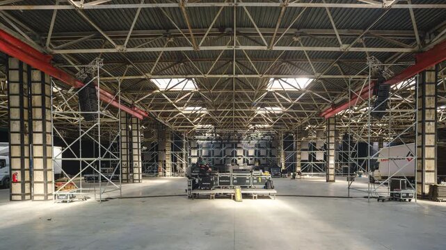 Tbilisi, Georgia - October 2 2025: Timelapse shot of Large Indoor Stage Setup With Scaffolding, Lighting Rigs, and Equipment in Warehouse