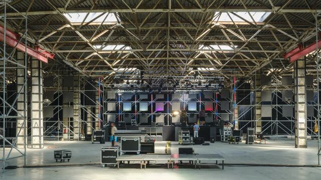 Tbilisi, Georgia - October 2 2025: Timelapse shot of Large Indoor Stage Setup With Scaffolding, Lighting Rigs, and Equipment in Warehouse