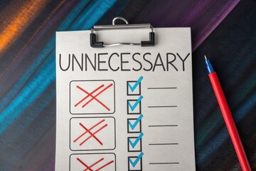 Eliminating Unnecessary: A checklist with the word unnecessary on top, crossed off items and some checked items, along with a pen. An idea of organization or prioritization.