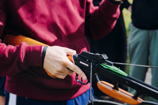 Crossbow shooting and archery at the shooting range, women and men practicing with arbalest at shooting gallery, compound bow training, aiming the target with arbalest at archery range, bow and arrows