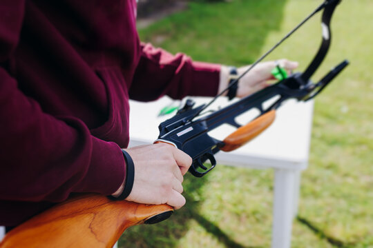 Crossbow shooting and archery at the shooting range, women and men practicing with arbalest at shooting gallery, compound bow training, aiming the target with arbalest at archery range, bow and arrows - Powered by Adobe