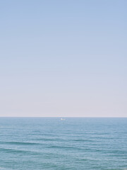 Small Boat Floating on Calm Blue Sea Under Clear Sky