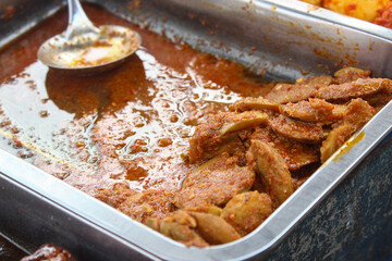A traditional Indonesian dish of rendang jengkol with soy sauce seasoning served in a stainless steel container