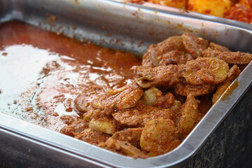 A traditional Indonesian dish of rendang jengkol with soy sauce seasoning served in a stainless steel container
