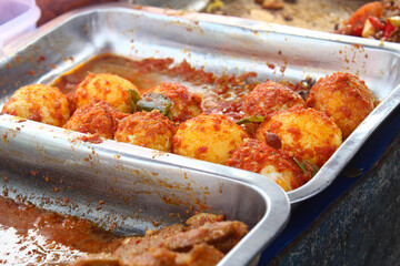 a traditional Indonesian dish of balado spiced eggs served in a stainless steel container
