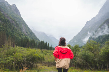 happy woman tourist trekking at mountain in Changping valley near Siguniang mountain in Sichuan...