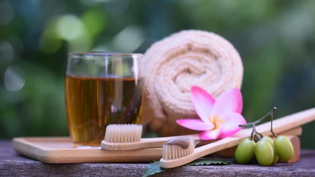 Neem leaf decoction is used for mouthwash and toothbrushing on natural background.