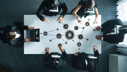 A diverse business team engages in a brainstorming session focused on cybersecurity solutions, surrounded by digital icons that symbolize security and connectivity in a modern office. Amity