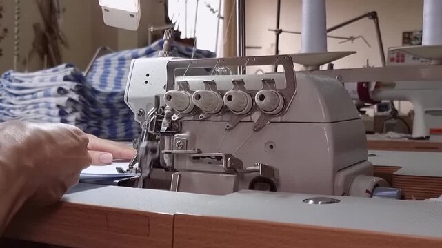 On the production overlay, a seamstress sweeps away a blue-and-white fabric, with a close-up of the seamstress' hands.