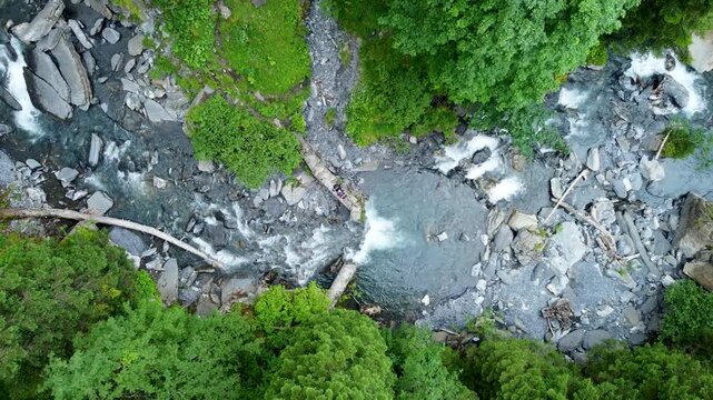 Zenithal drone shoot of an old floodgate in a river. The drone pilot is laying in the middle of the building.