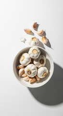 Fresh Garlic Bulbs and Cloves in White Bowl on Bright Surface